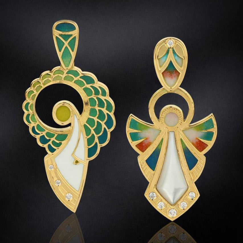 Two gold-colored pendants with intricate designs on a black background