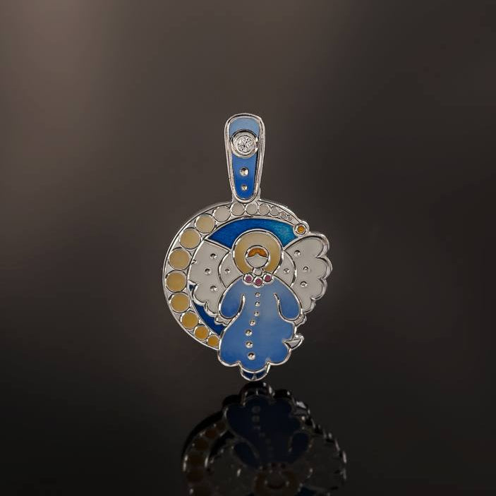 Pendant with angel design on a reflective surface against a dark background