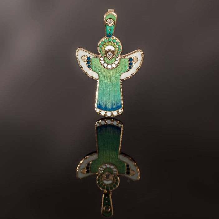 Green angel pendant on a reflective black surface