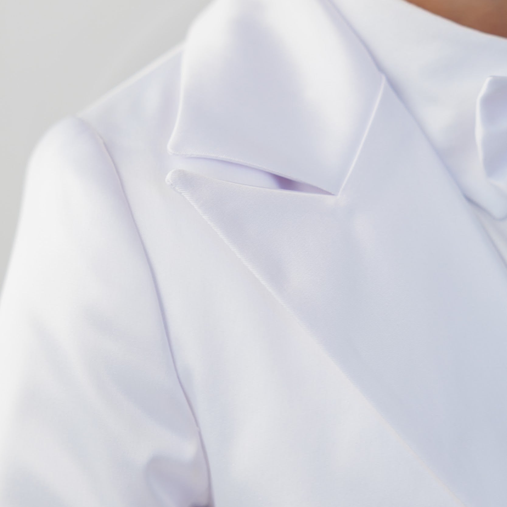 Close-up of a white lab coat on a neutral background