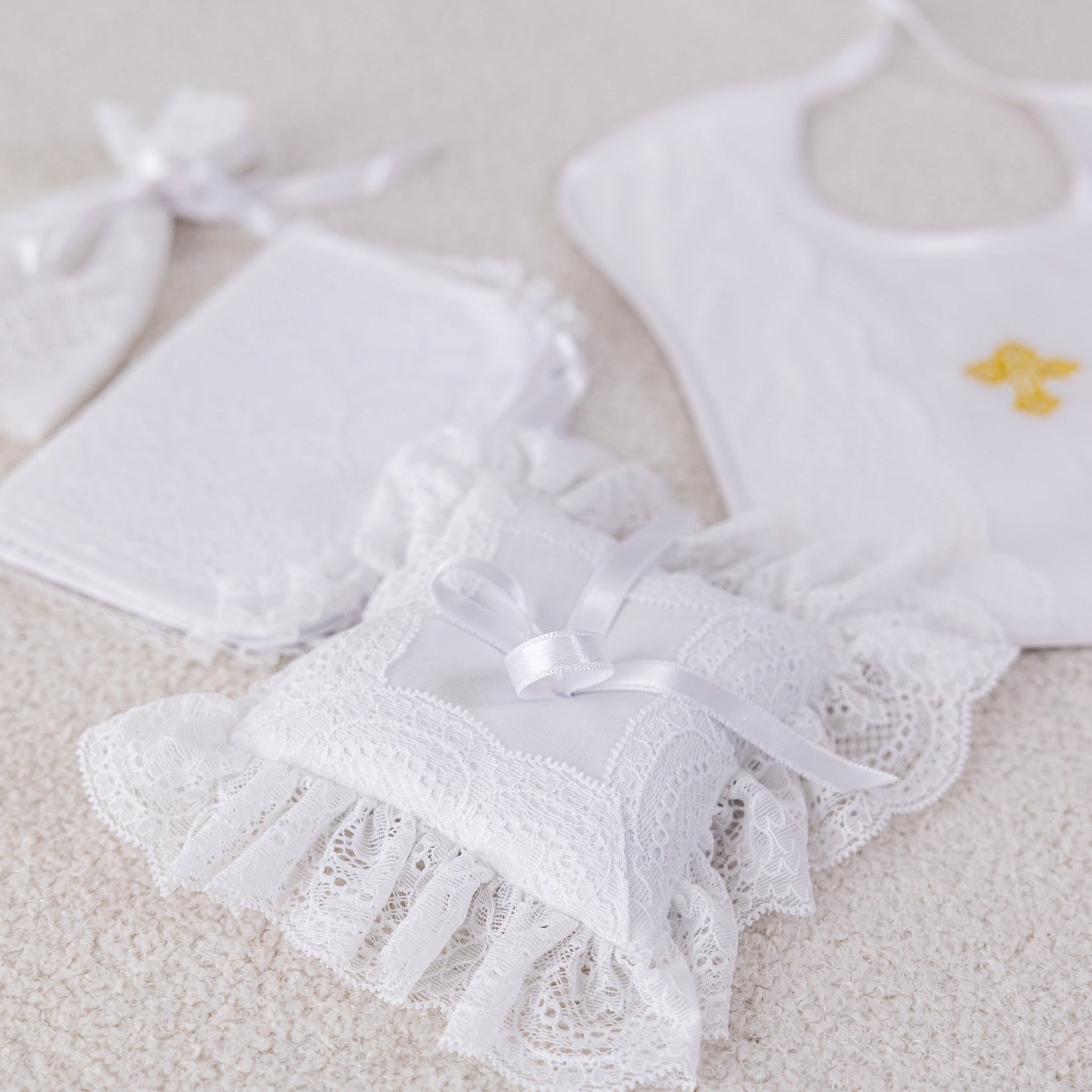 White baby bib and booties set on a light background
