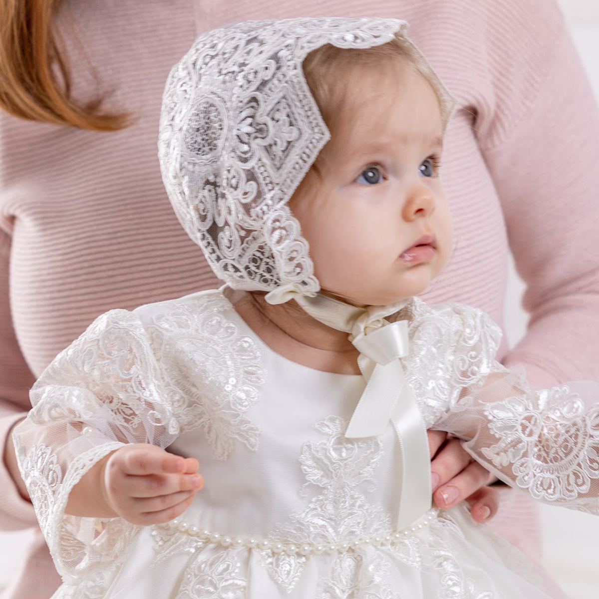 Baby in a lace baptism bonnet