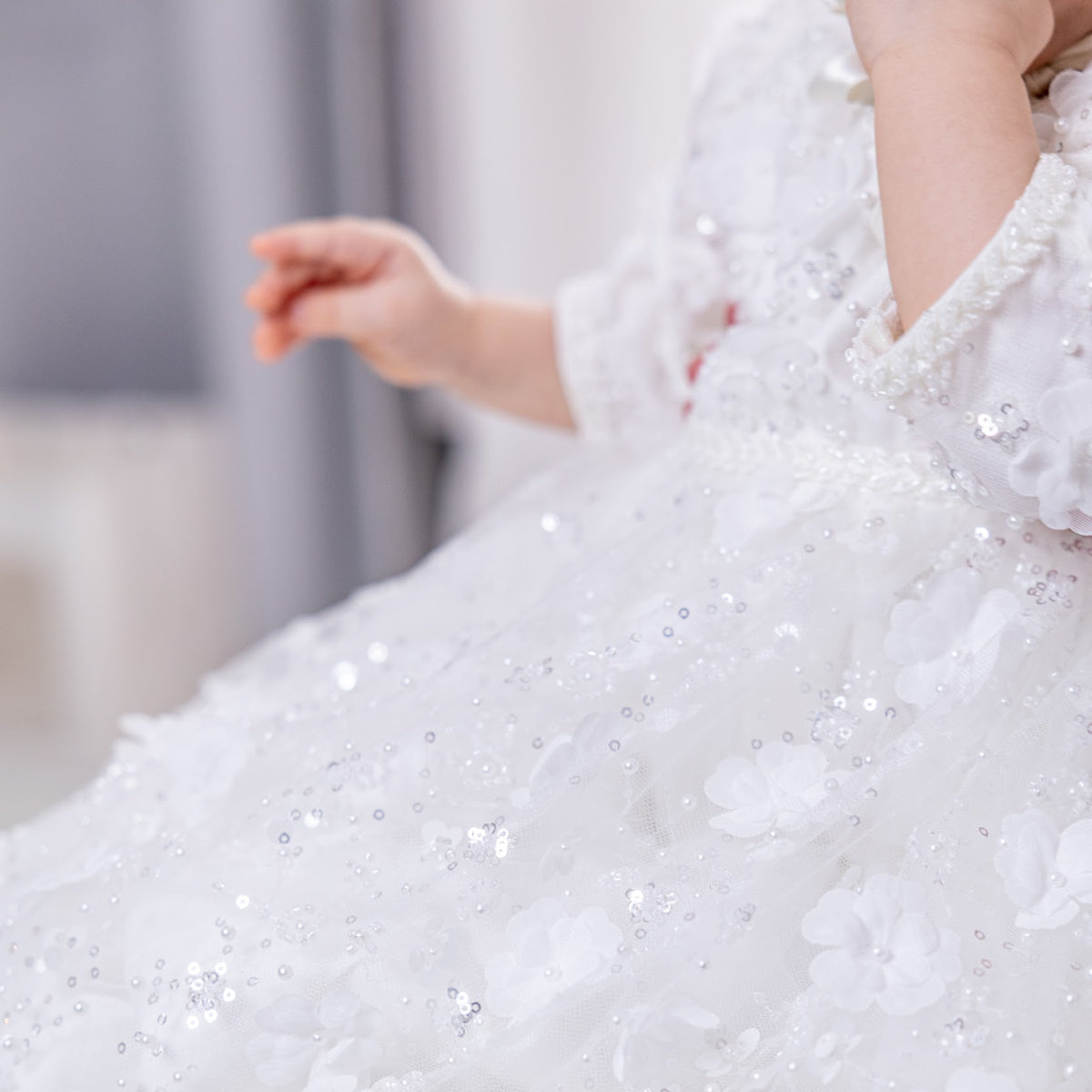 Close-up of a white sequin dress with a blurred background