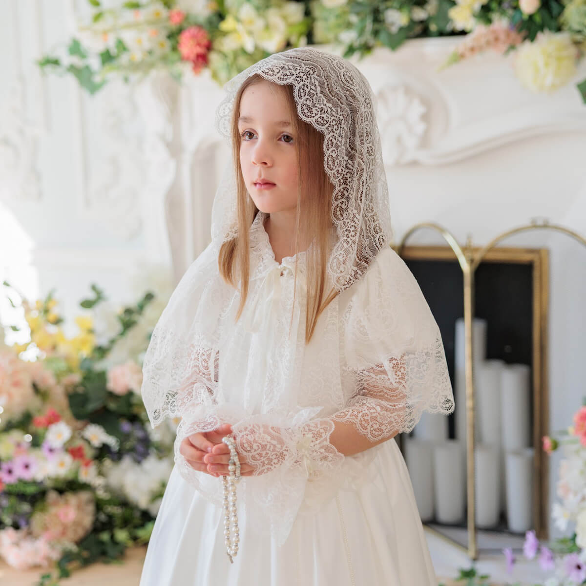 Young girl in Silk First Communion Dress with Lace Mantilla holding rosary beads