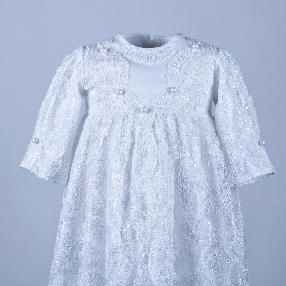 Girls Christening Gown with pearl embellishments on a gray background