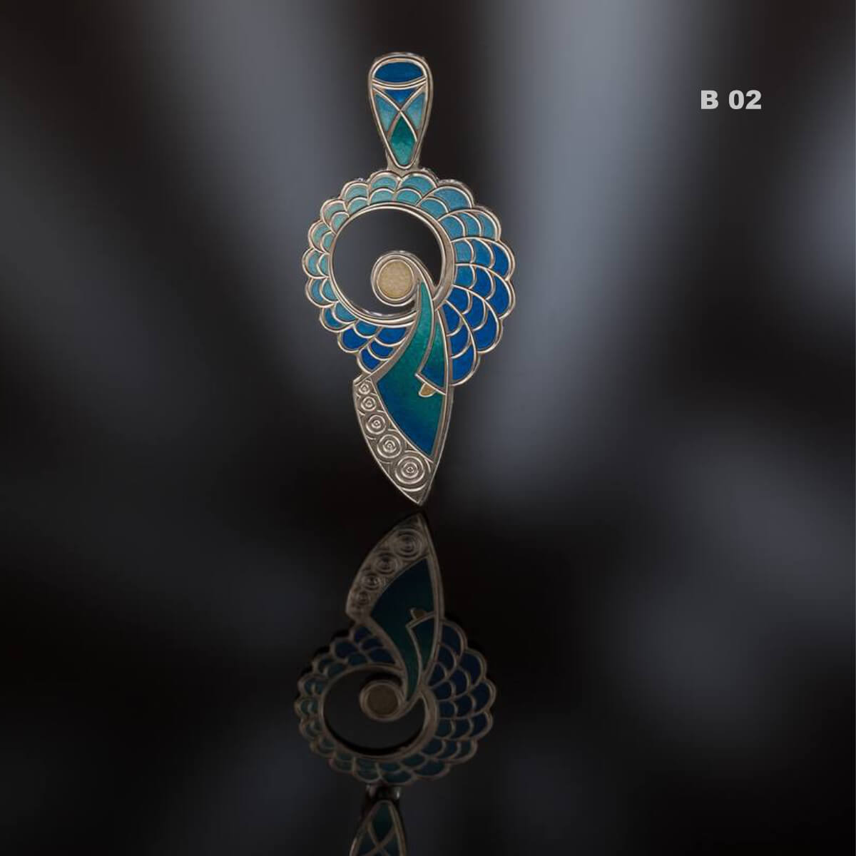 Decorative pendant with blue and silver design on a reflective surface