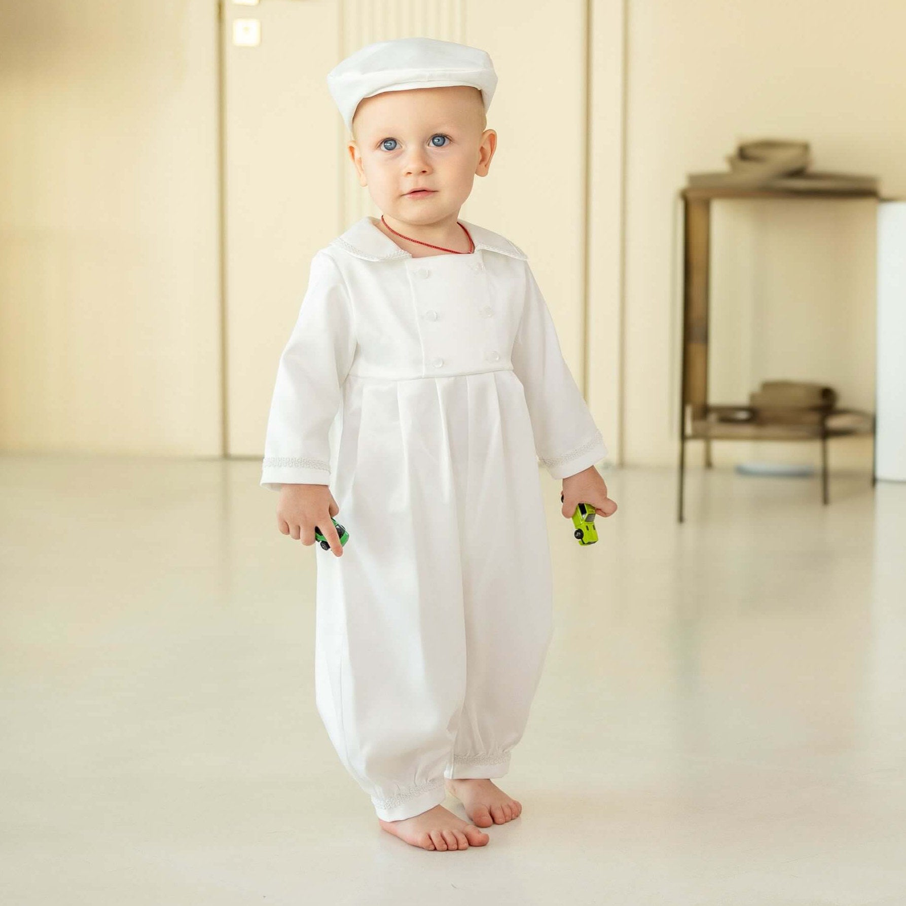 Baby in a standing in a minimalistic room in Baby Boy Christening Romper
