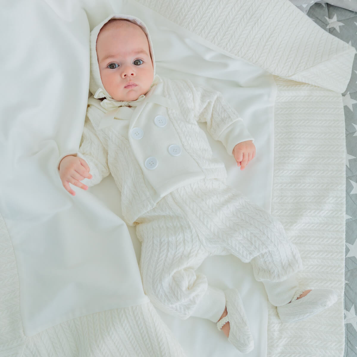 Baby wrapped in aBaby Boy Christening Suit on a soft surface