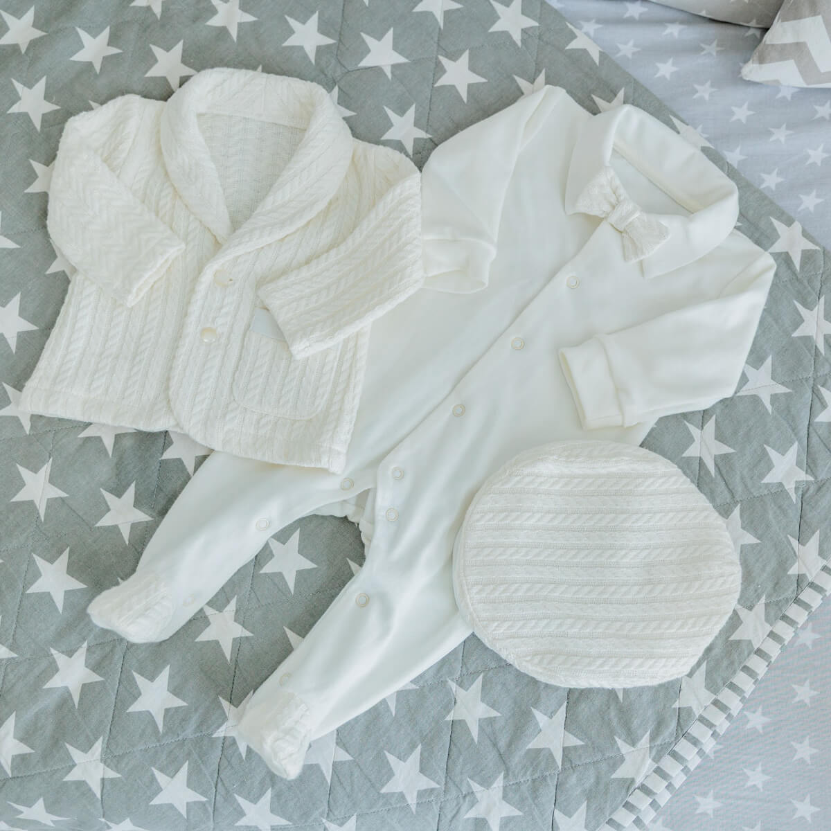 Newborn Coming Home Knit Set with tights and headband on a gray blanket with star pattern