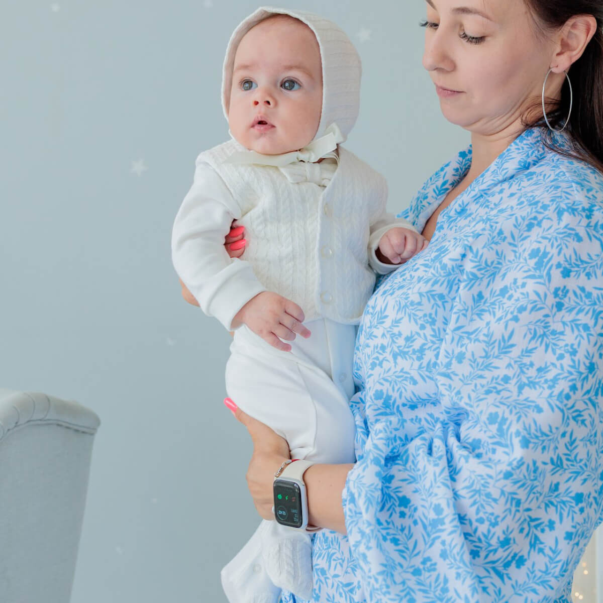 Woman holding a baby dressed in Coming Home Jersey Outfit against a light gray background