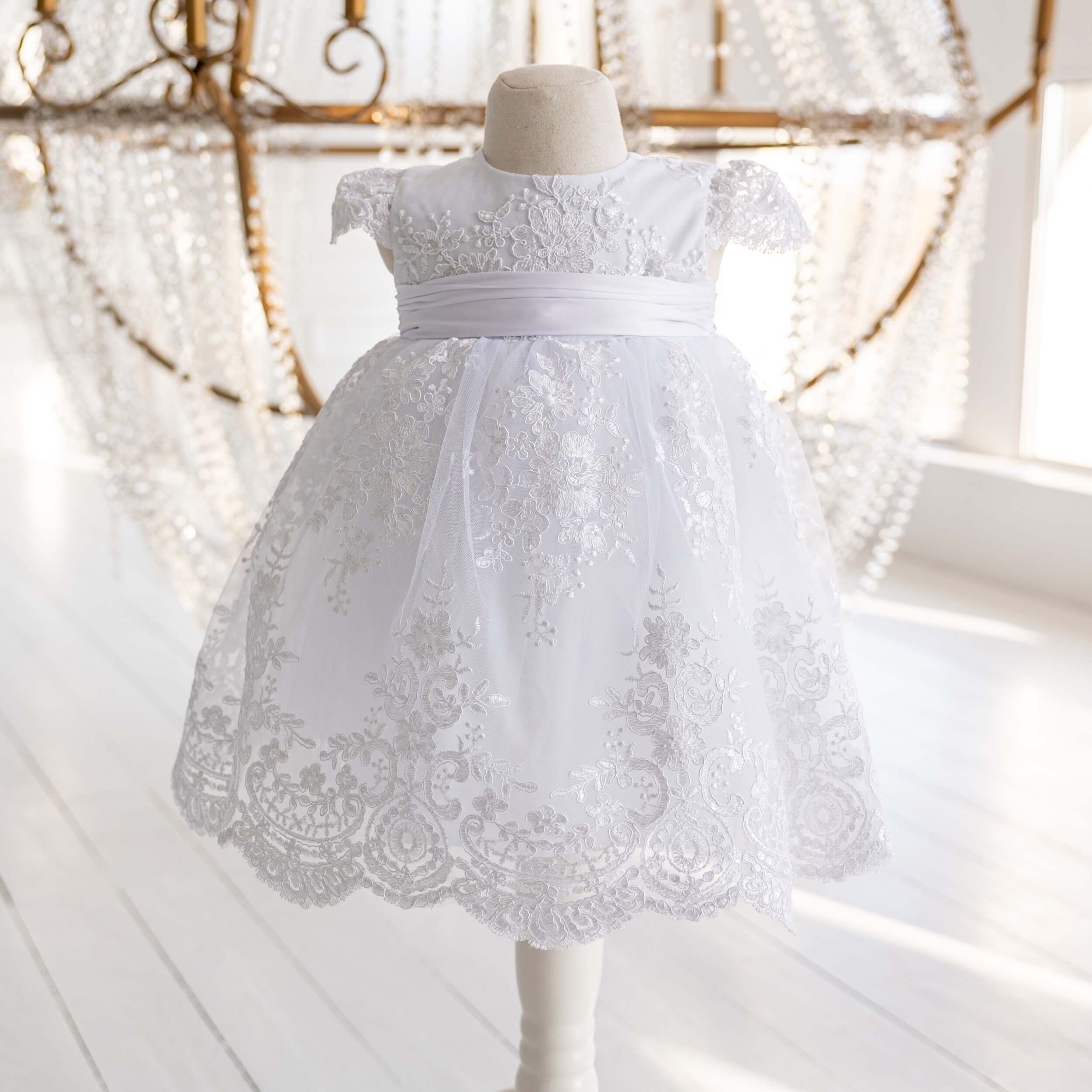 Lace Baptism Dress on a mannequin against a decorative background