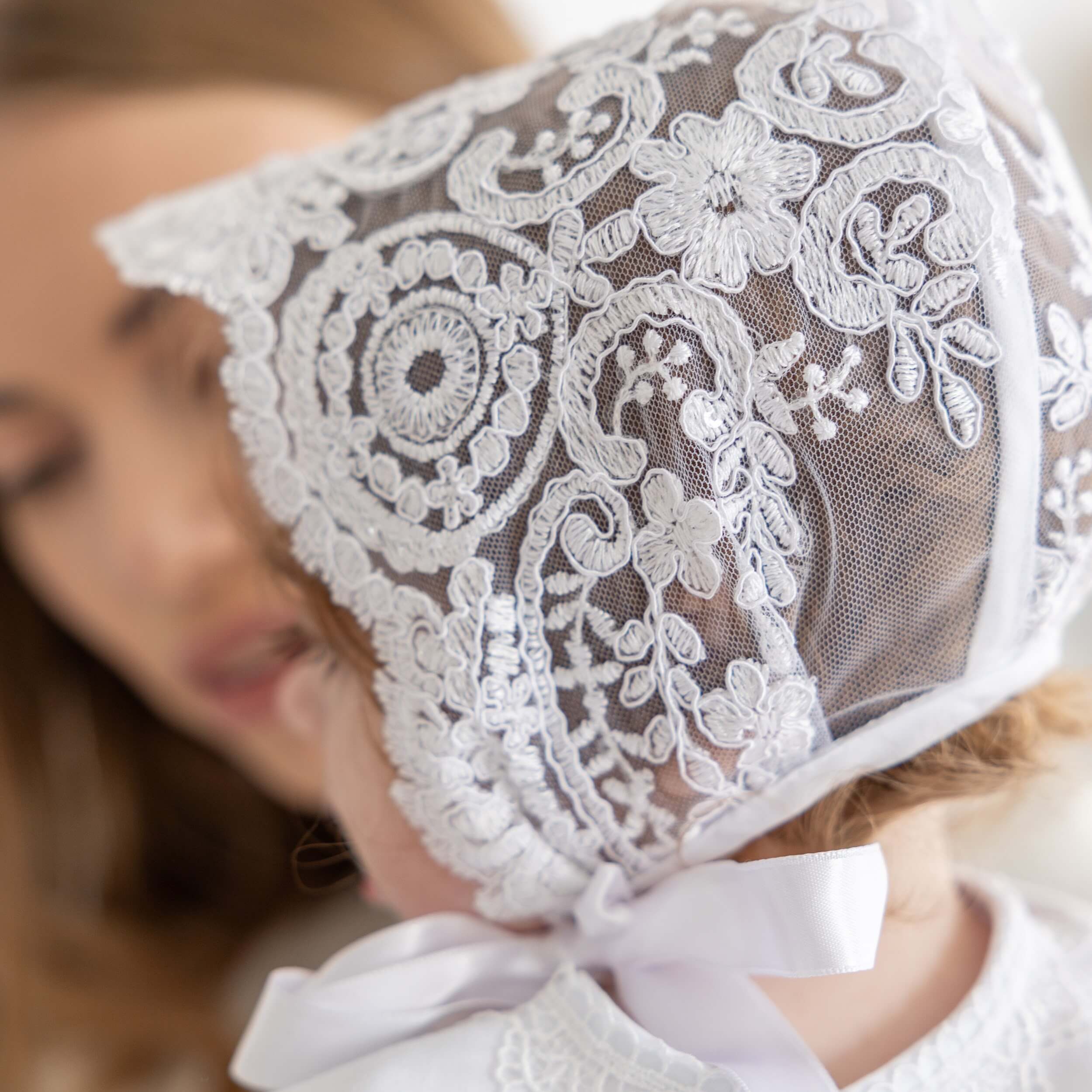 Close-up of silk christening bonnet with a blurred background