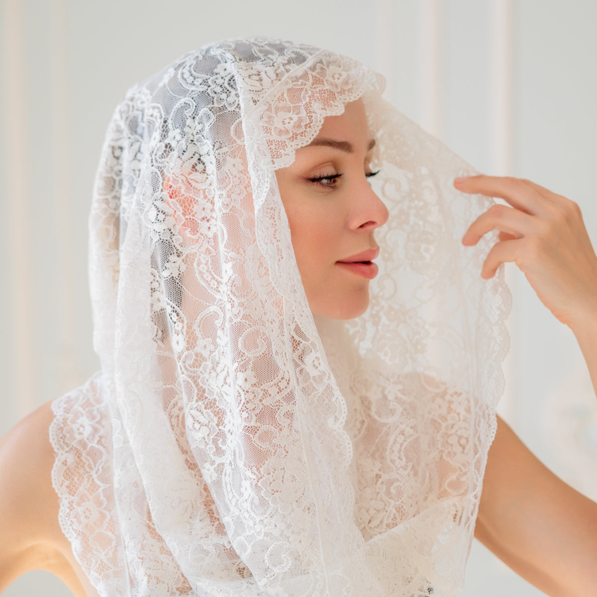 Woman wearing a Catholic Infinity Veil against a light background