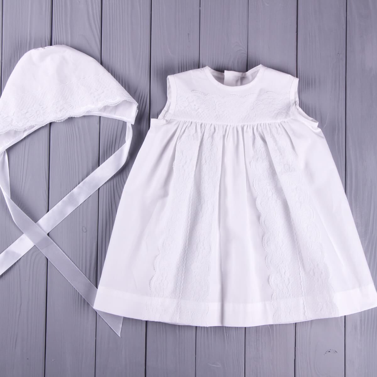 Summer Baptism Dress and bonnet on a wooden surface