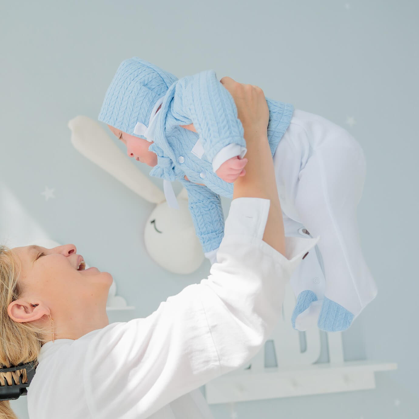Woman holding a baby dressed in Boy Christening Hat