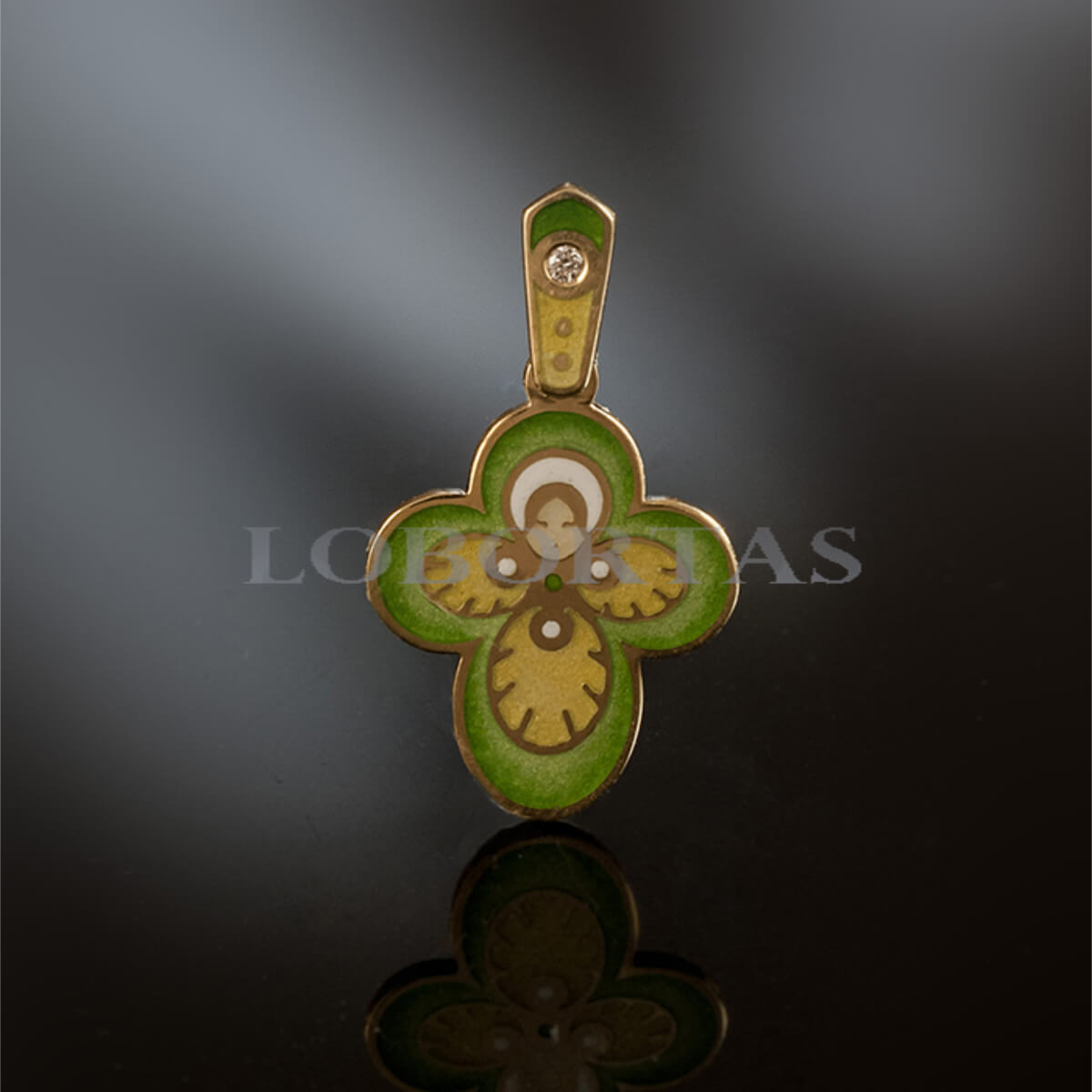 Gold and green pendant with intricate design on a dark background