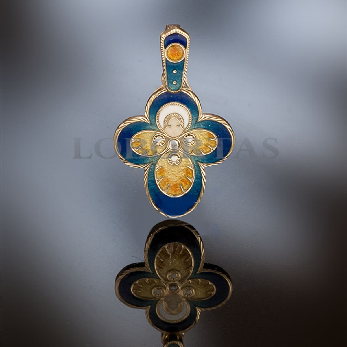 Decorative cross pendant with blue and gold colors on a reflective surface.