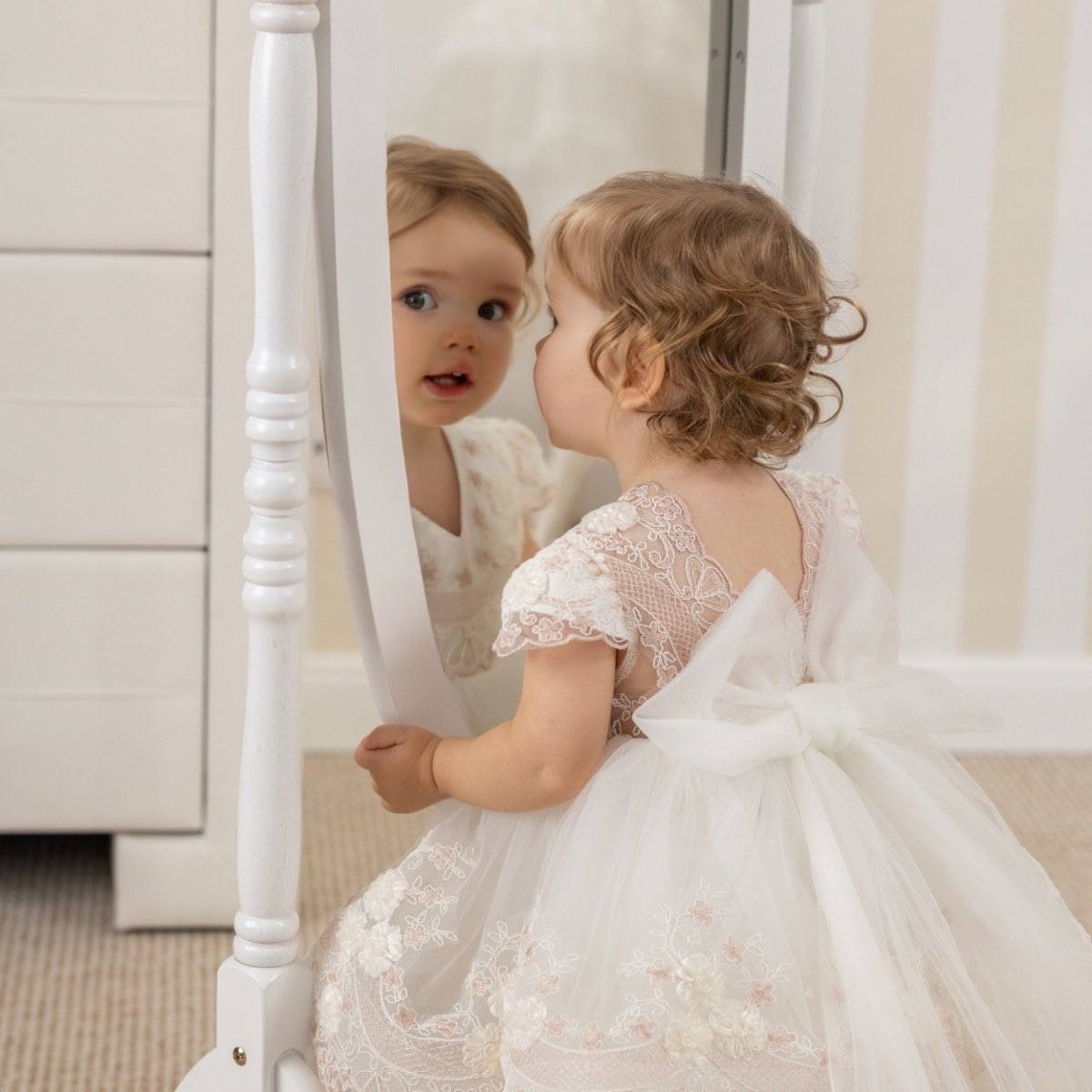 Child in a Baptism Dress with Detachable Train sitting in front of a mirror