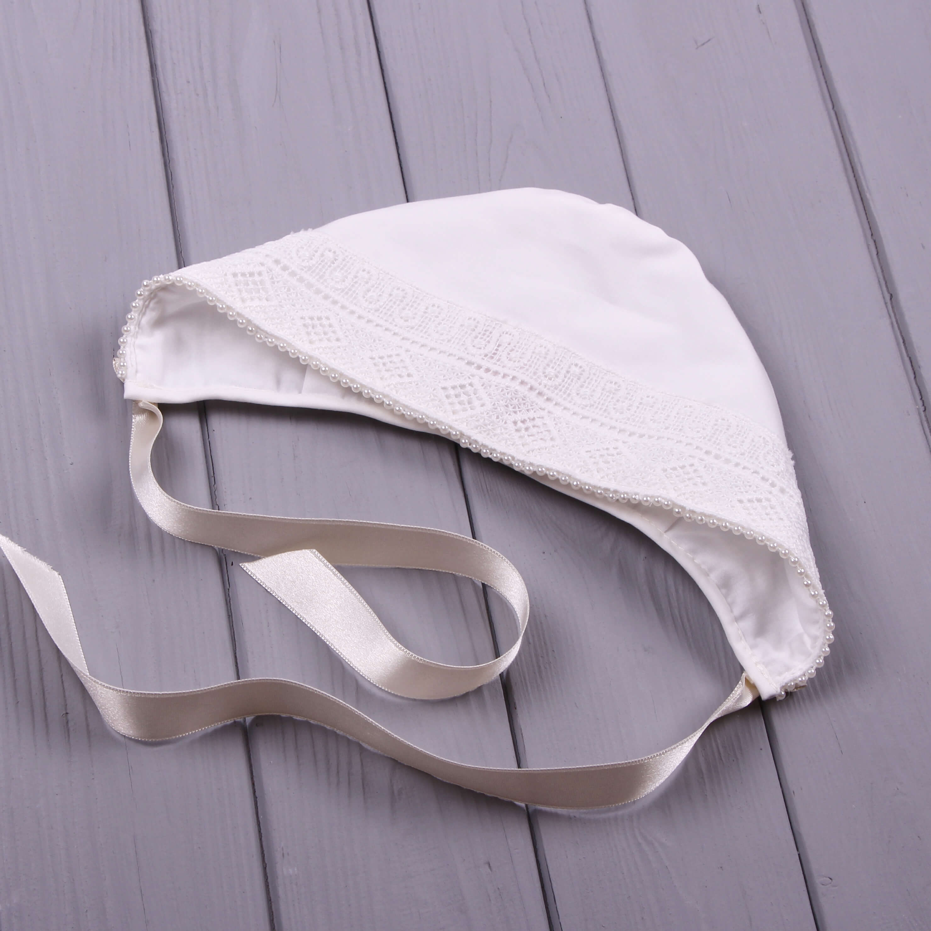 Boy Baptism Hat with a ribbon on a gray wooden surface
