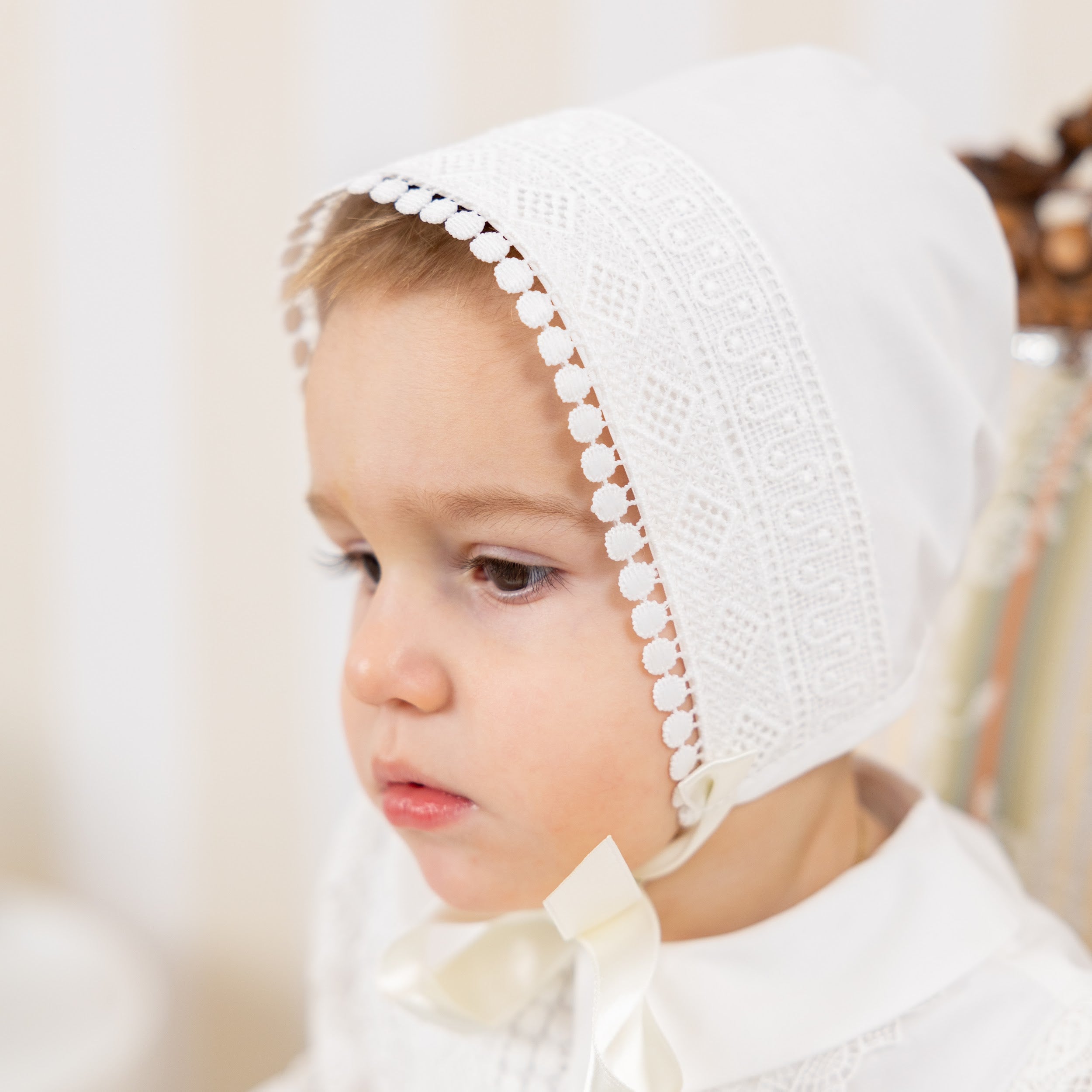 Child wearing a Boy Baptism Hat with a blurred background