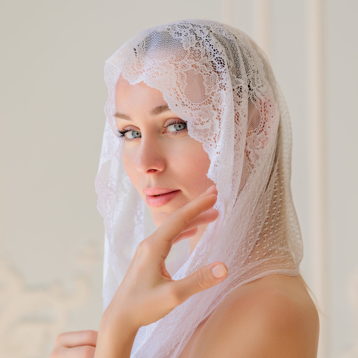 Woman wearing a Catholic Infinity Veil against a neutral background