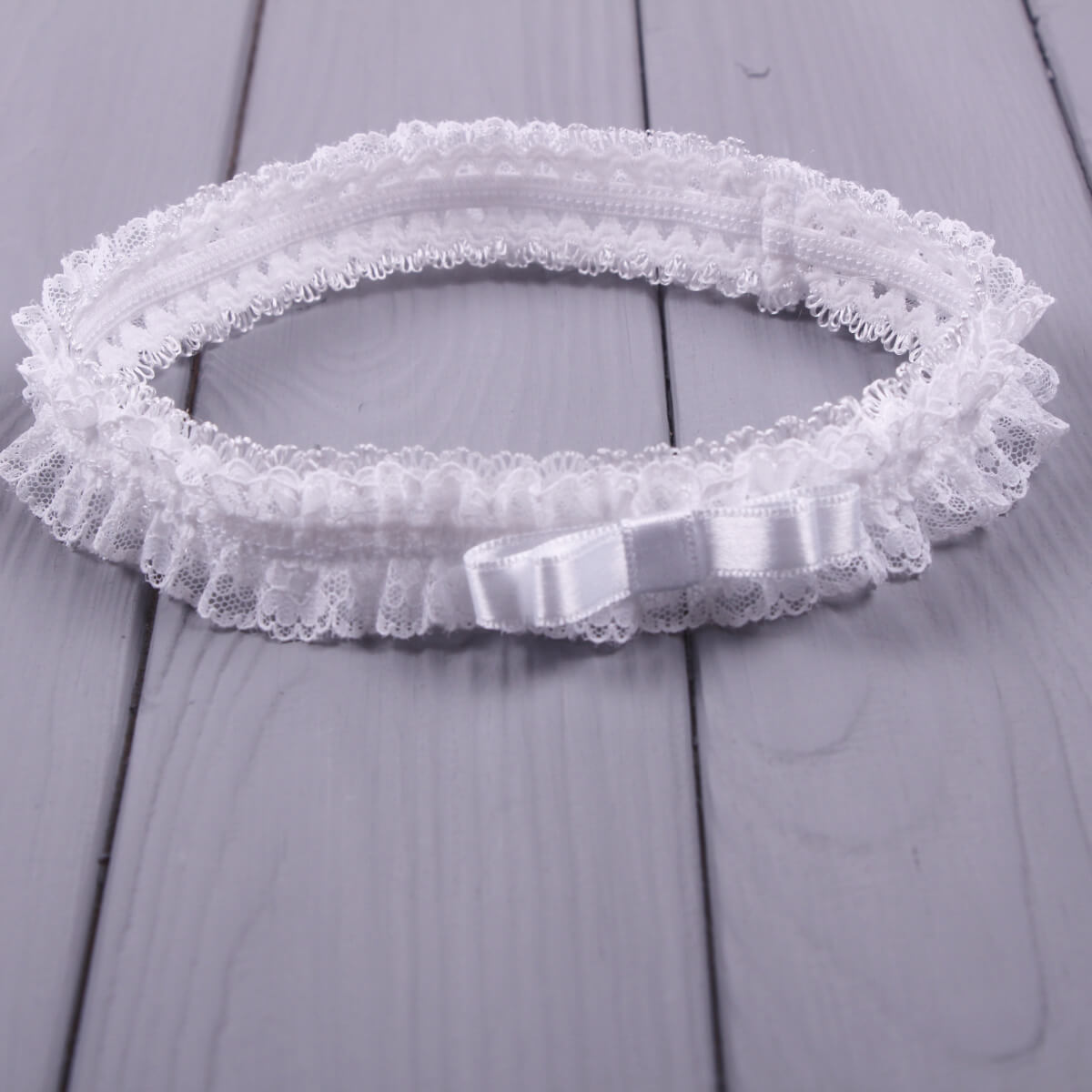 baby headband for baptism on a wooden surface
