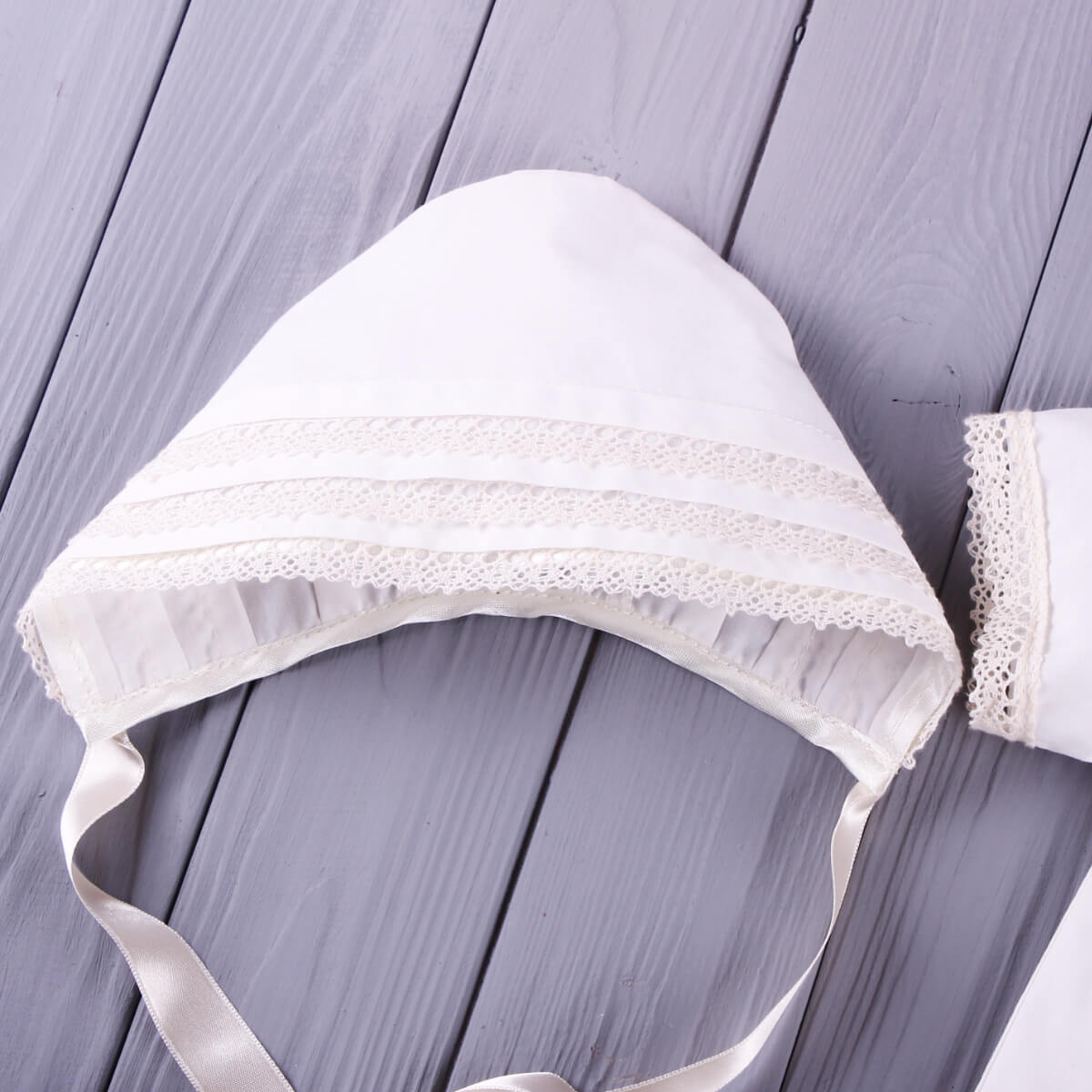 Baby Christening Bonnet on a wooden surface