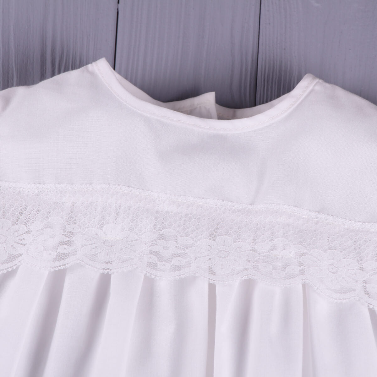 Baptism Outfit Set for Baby Girl with lace detailing on a wooden surface
