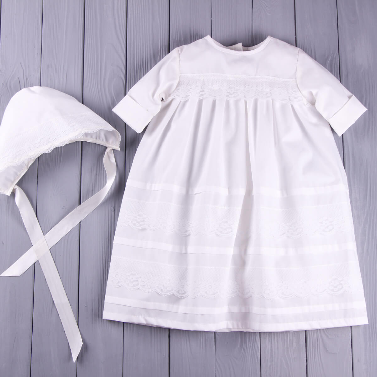 Baptism Outfit Set for Baby Girl and bonnet on a wooden surface