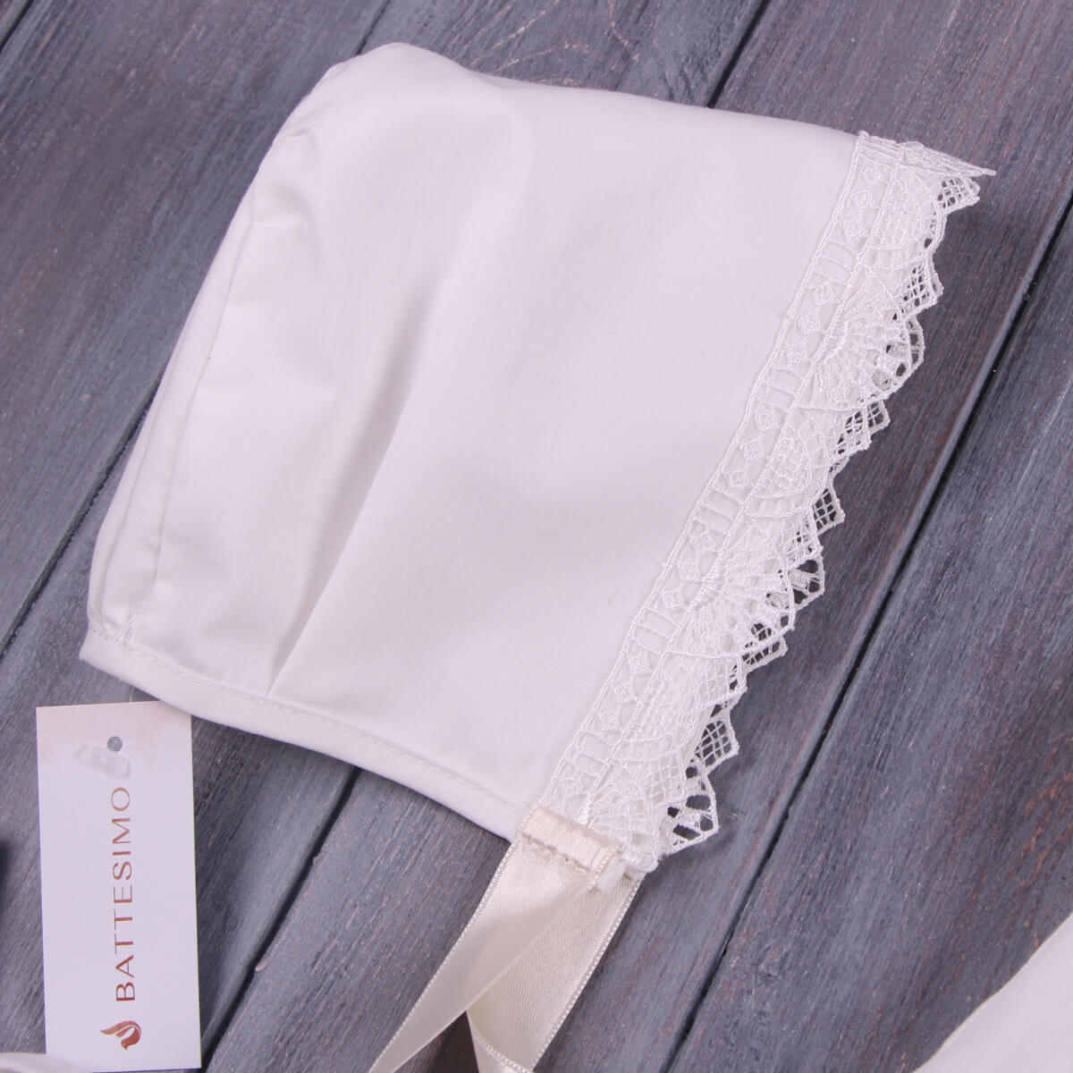 Boy Baptism Hat with lace trim on a wooden surface, featuring the Battesimo brand.
