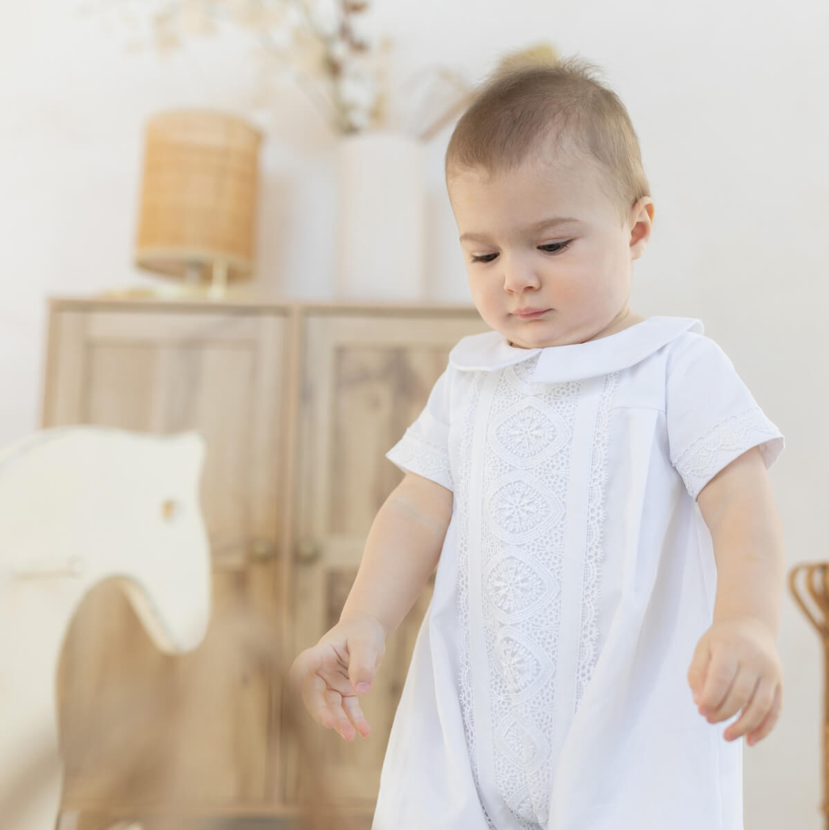 Child wearing a Baby Boy Baptism Romper in a softly blurred indoor setting