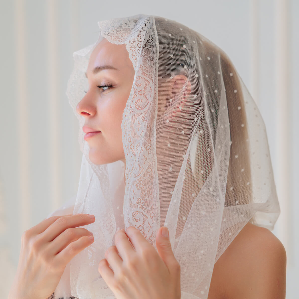 Woman wearing a Catholic Infinity Veil against a white background