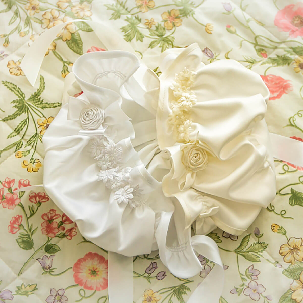 Silk Baptism Bonnet with floral embellishments on a floral fabric background