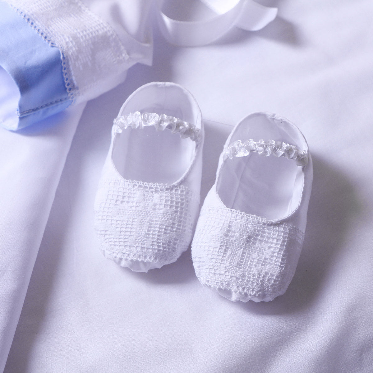 Christening Booties with mesh design on a light background