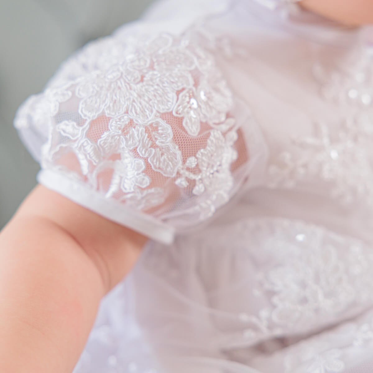 Close-up of a baby's lace-edged o Baptism Set for Girl with a blurred background