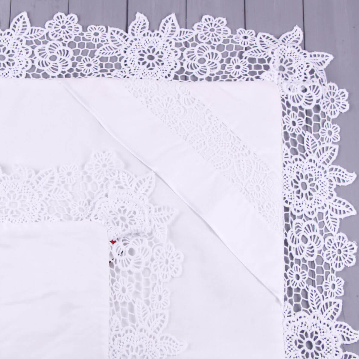 White lace christening blanket on a light gray background