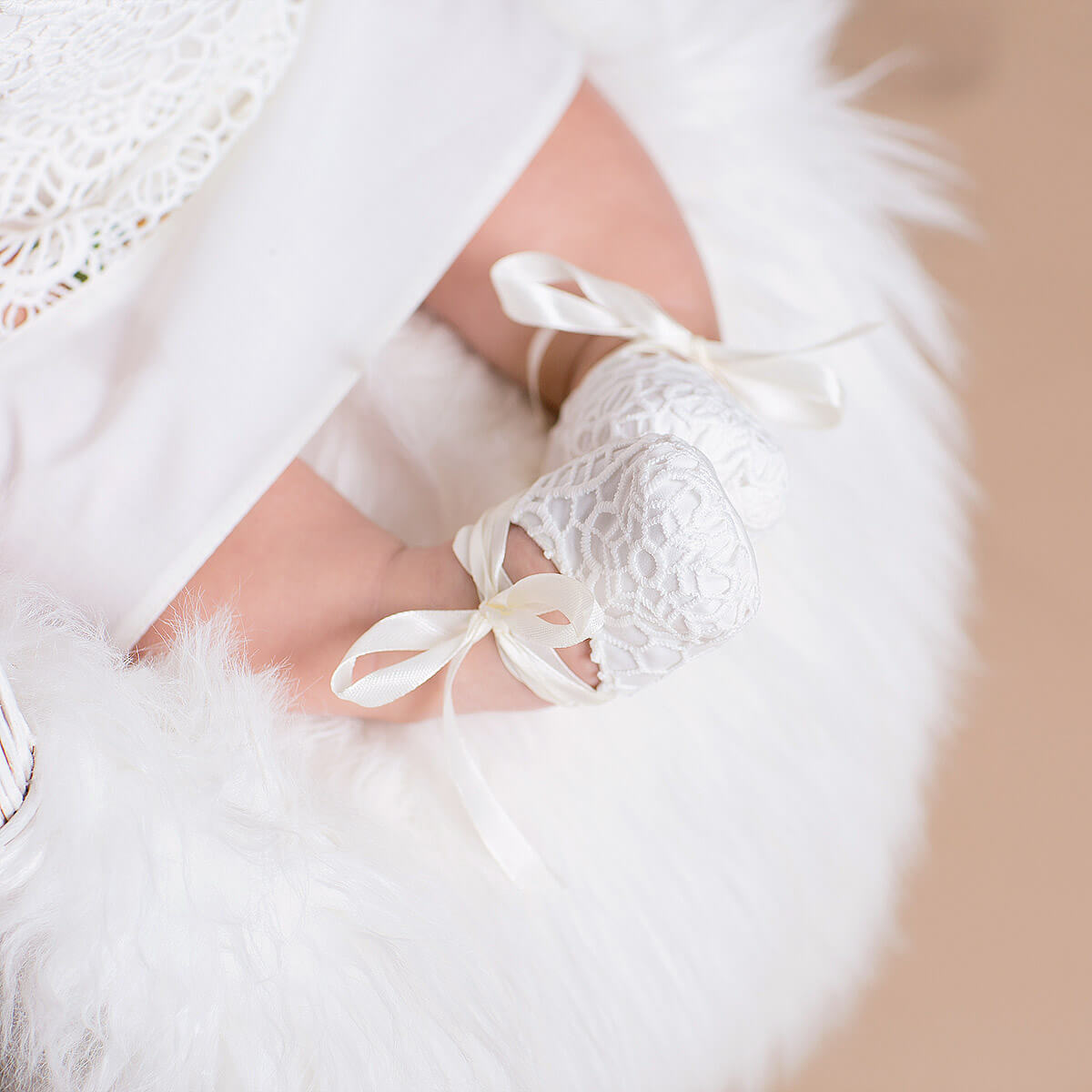 Close-up of a person wearing with Baptism Booties ribbons in a soft, blurred background.