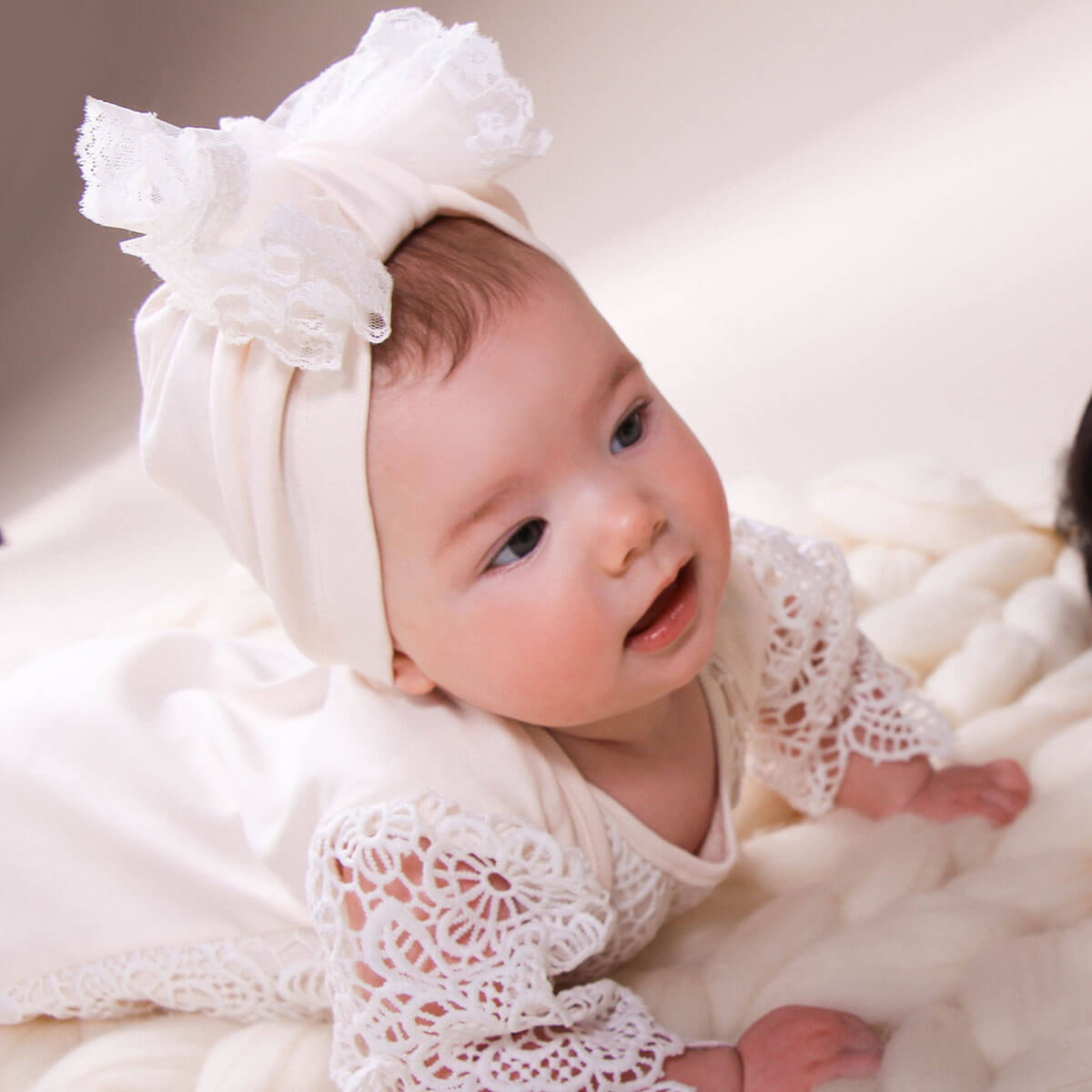 Baby wearing a Coming Home Outfit and headband on a soft, neutral background