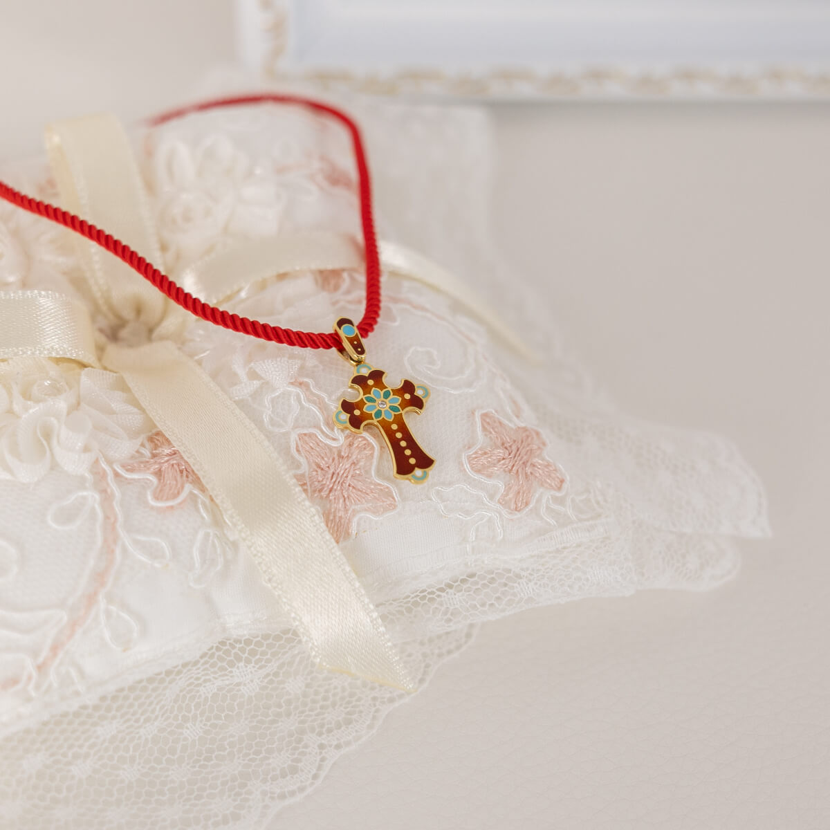 Necklace with a cross pendant on a textured white surface