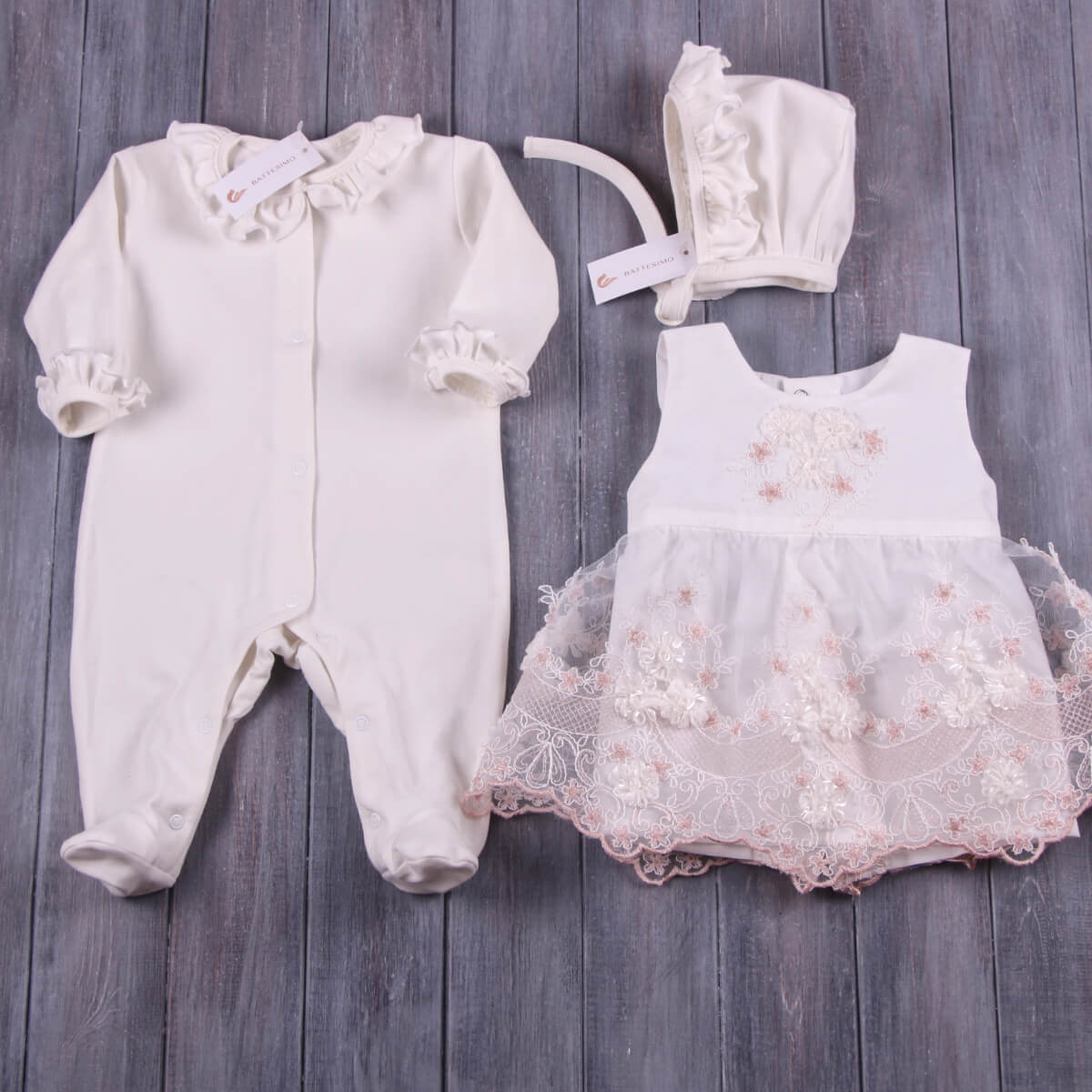 Baby outfit set with Coming Home Outfit, and bonnet on a wooden surface