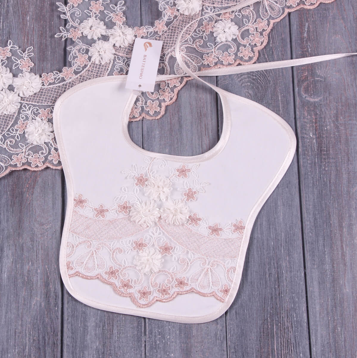 Baptism Bib with Lace details on a wooden surface
