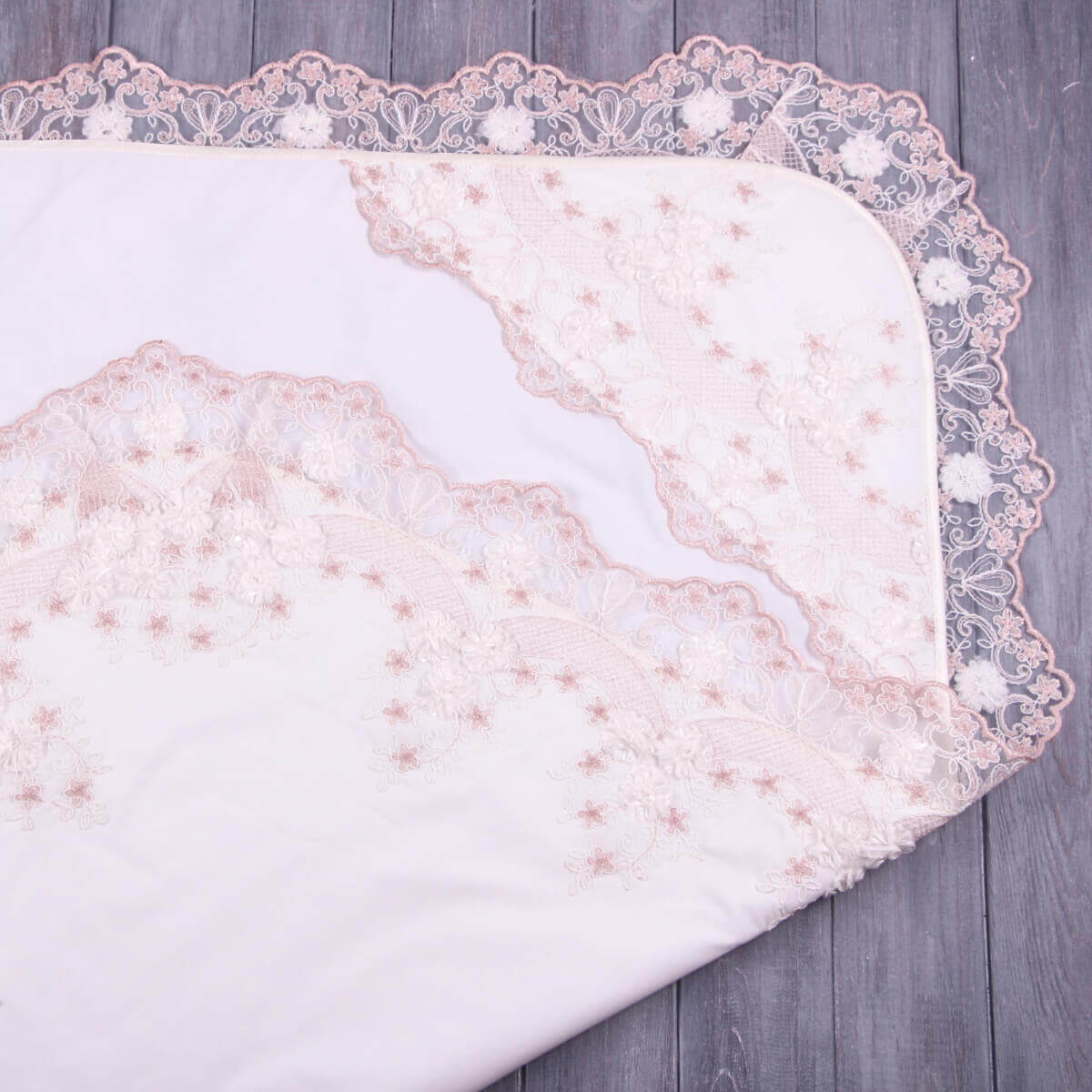 White lace baptism blanket on a wooden surface