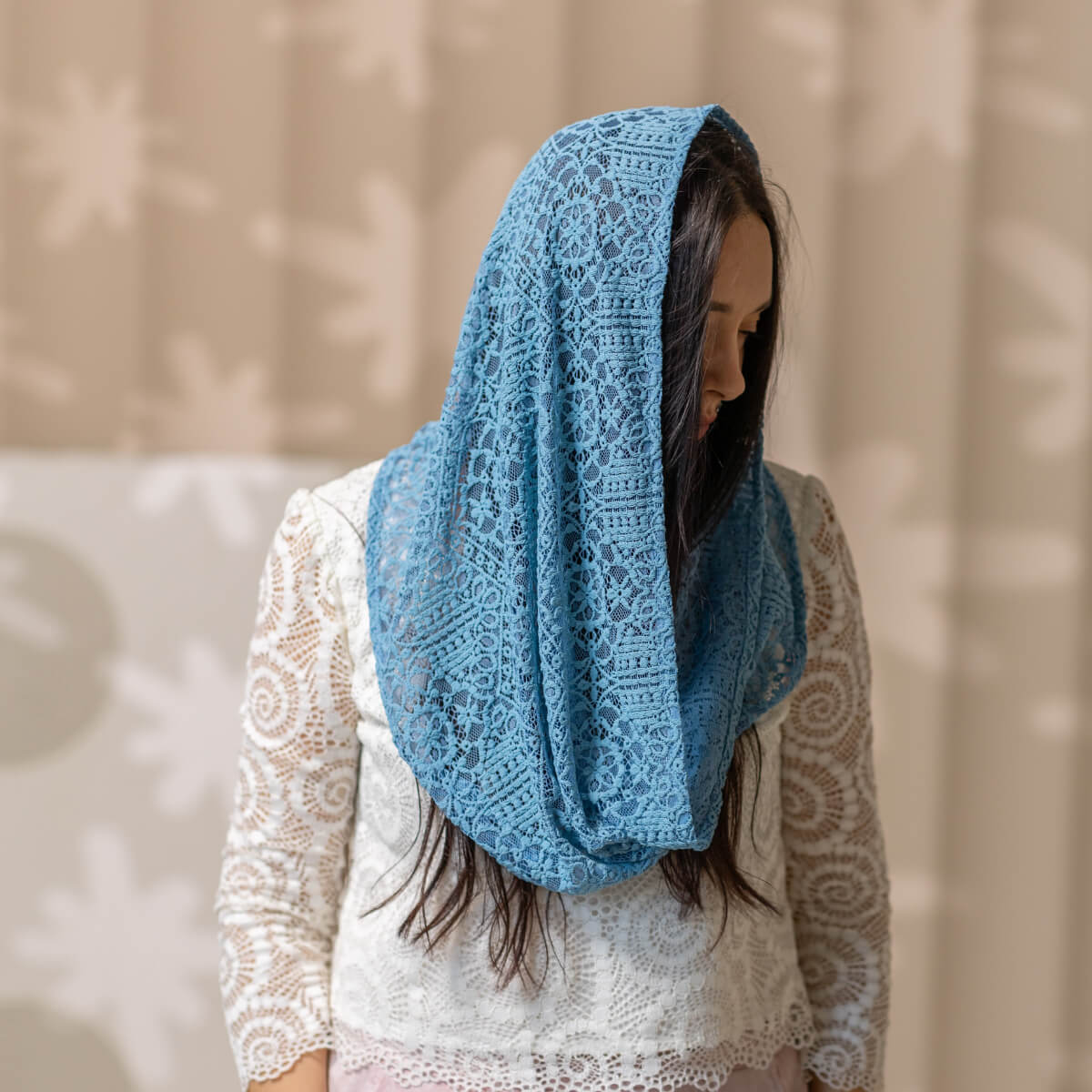 Woman wearing a Catholic Infinity Veil against a neutral background