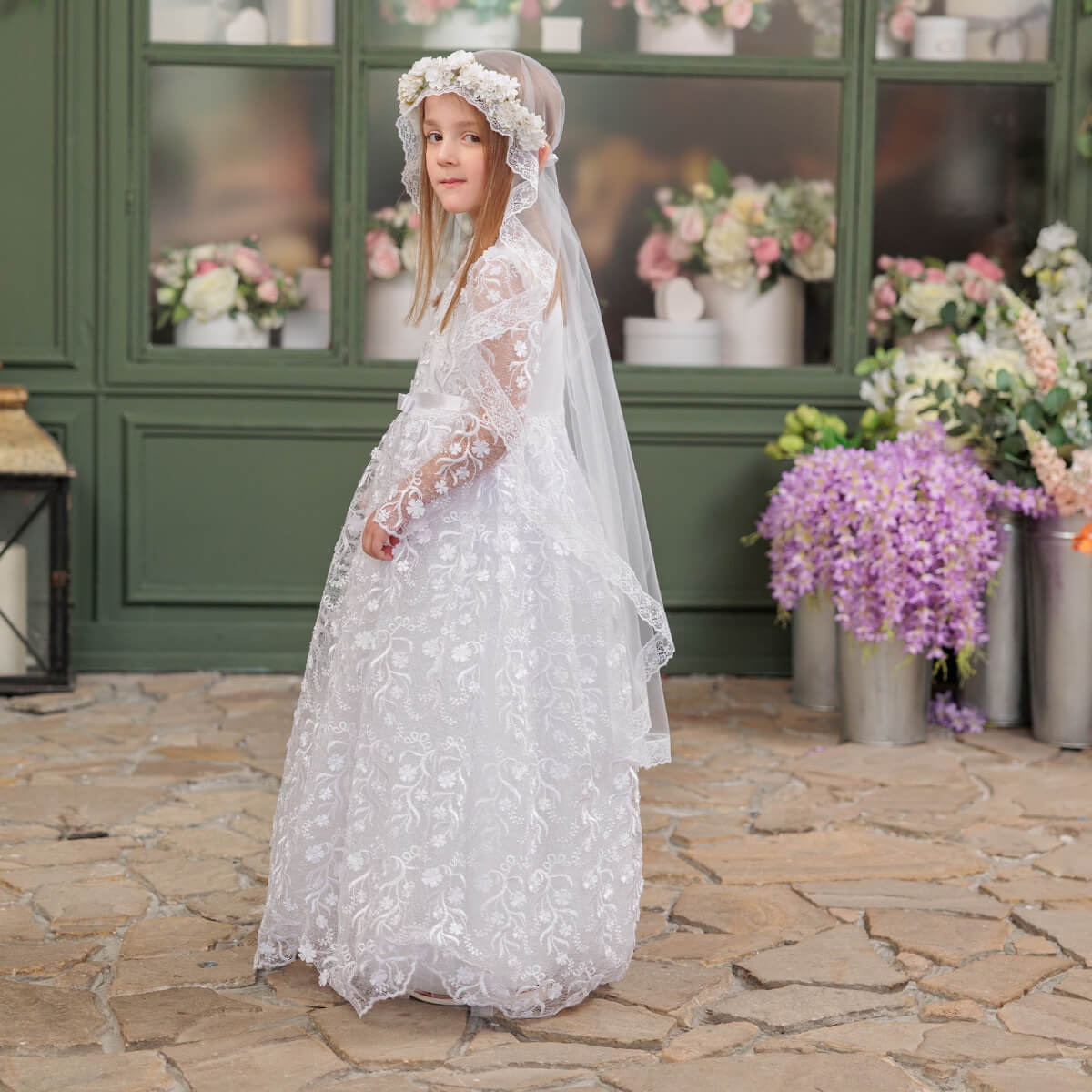 Young girl in a Communion Dress with Flower Wreath Veil in the background.