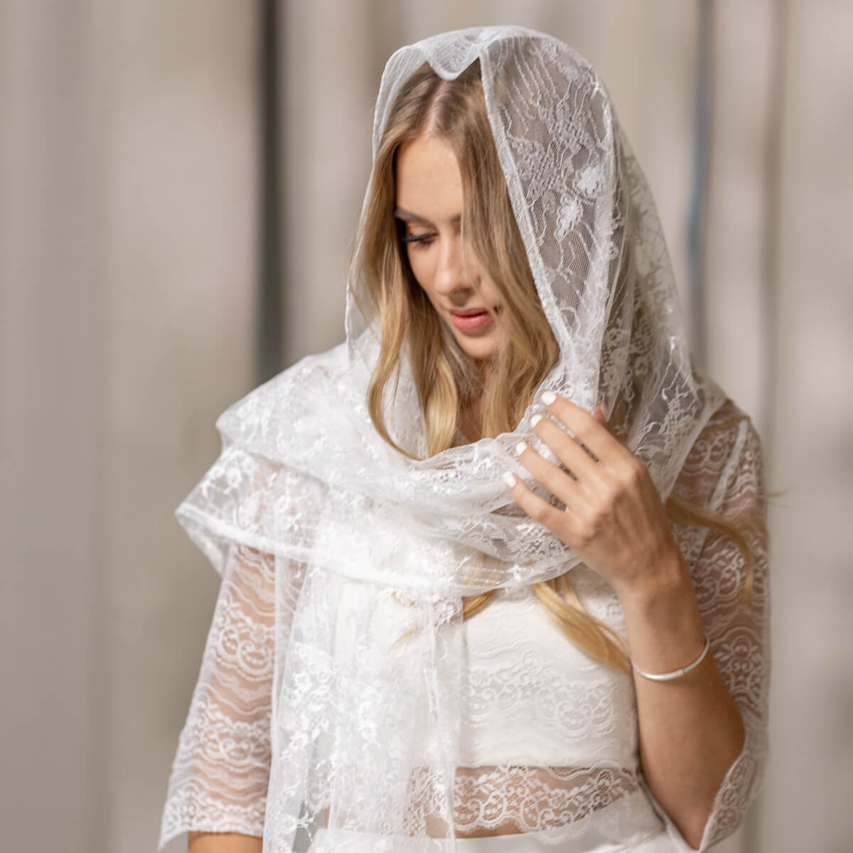 Woman wearing a Lace Chapel Veil against a neutral background