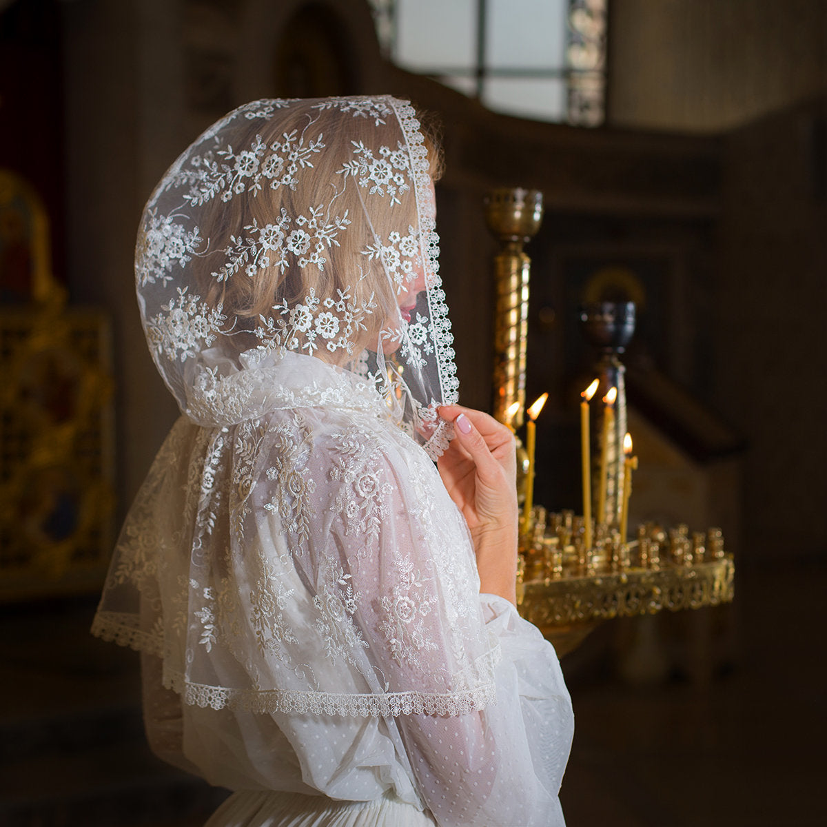Close-up of a person wearing a Hooded Lace Veil in an indoor setting with blurred background