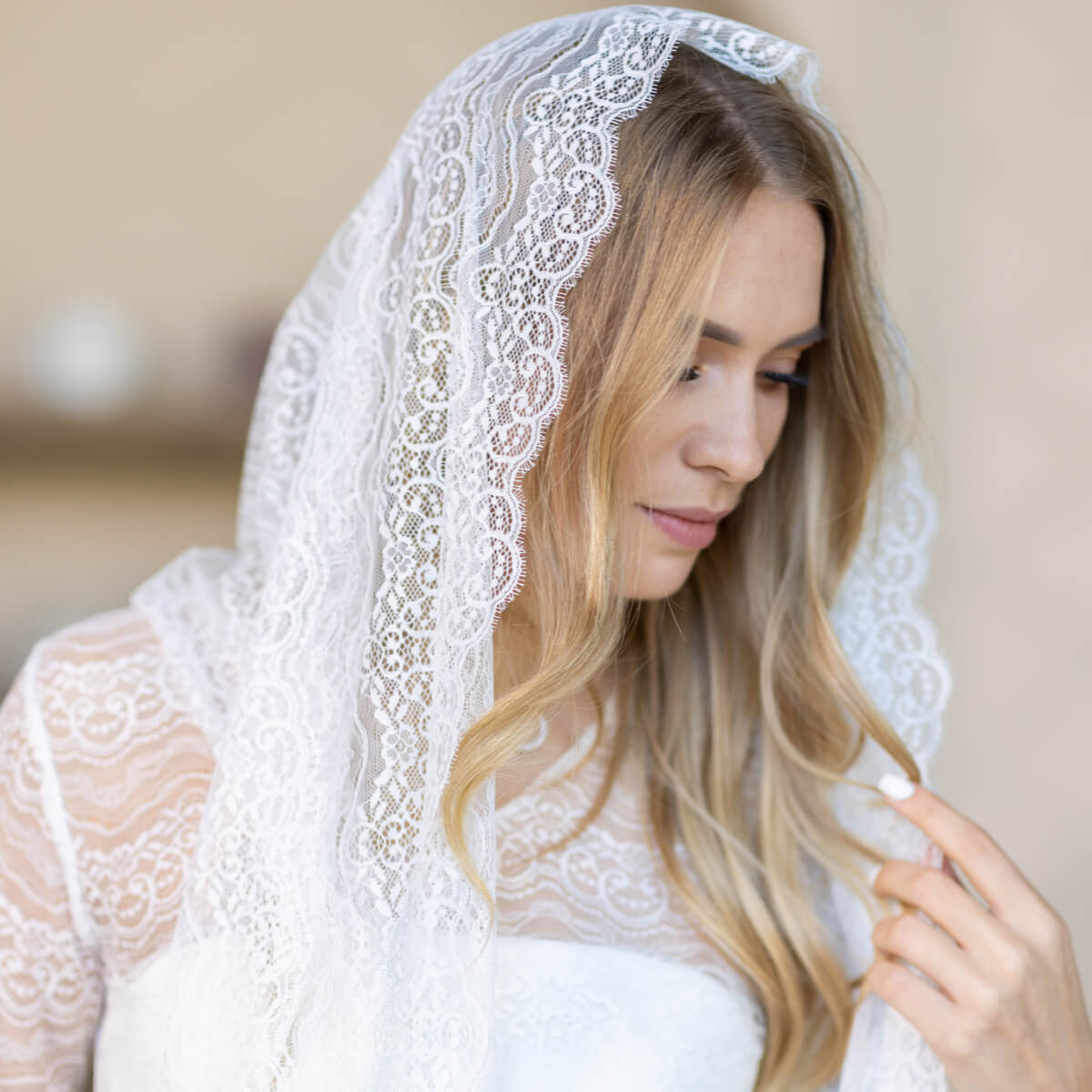 Woman wearing a Lace Chapel Veil against a neutral background