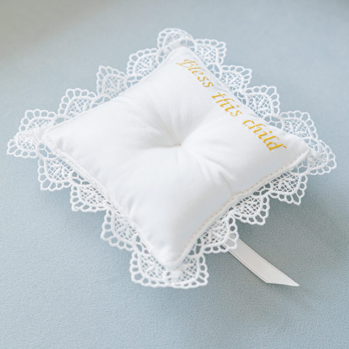 Christening Ceremony Pillow and embroidered text on a light blue background