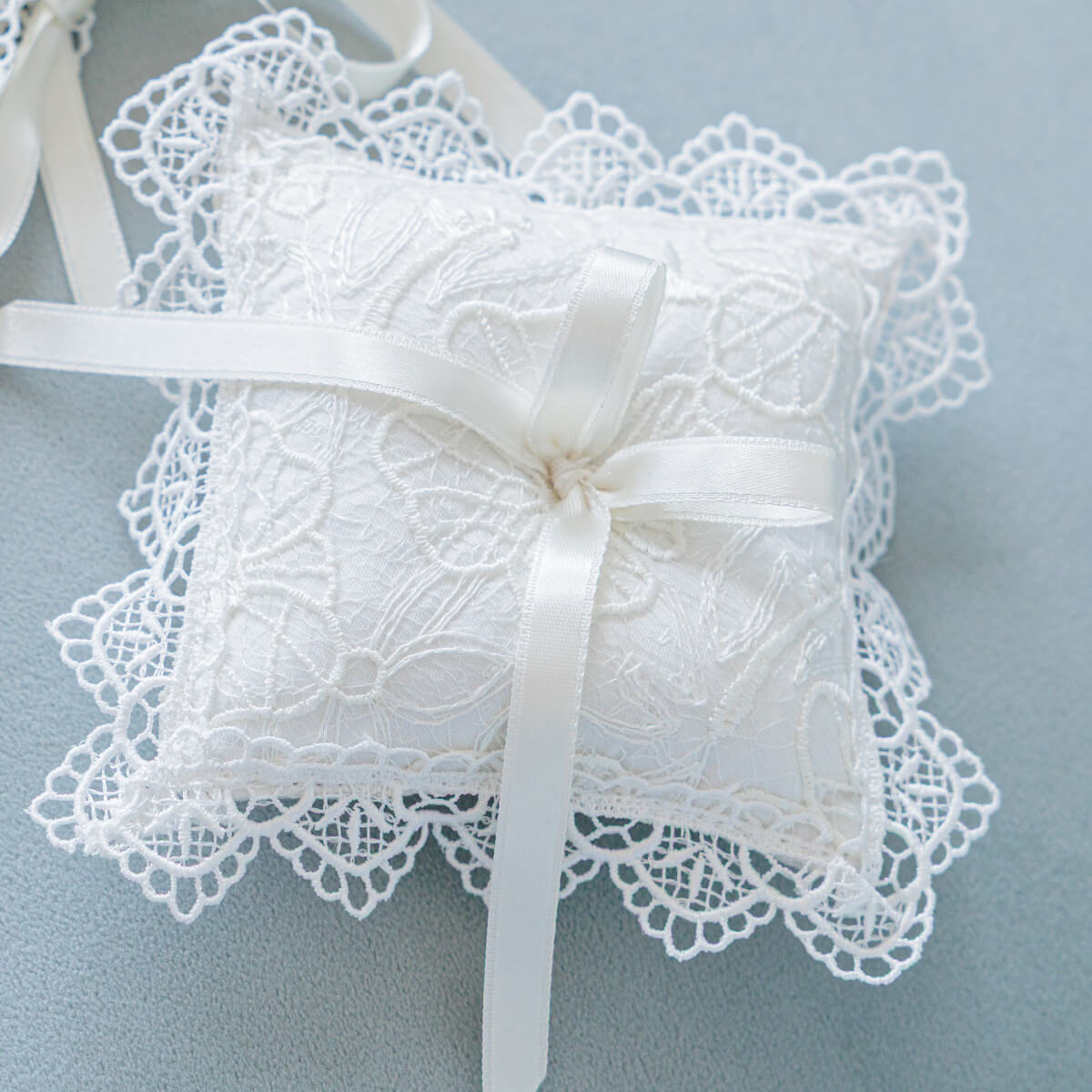 Christening Ceremony Pillow with a ribbon on a light blue background