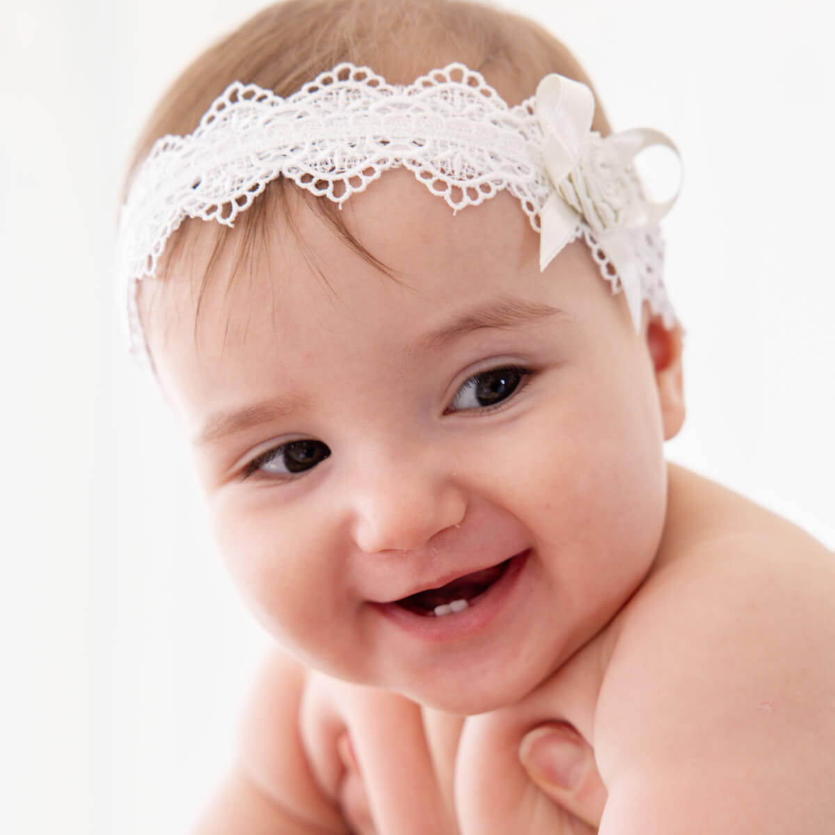 Girl wearing a baby headband on a white background